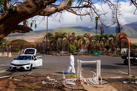 The Rev Ai Hironaka walks in the parking lot as he visits his temple and residence. Scorched palm trees are in the background