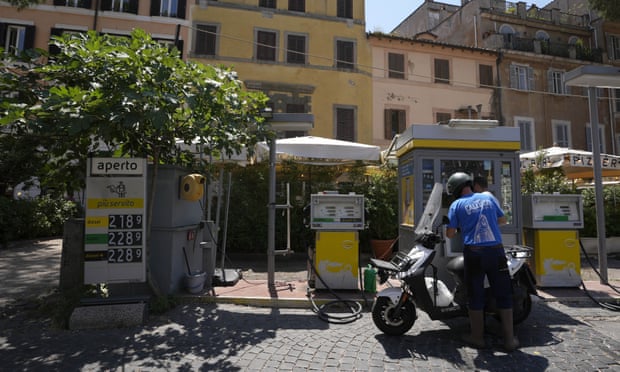 Un homme remplissant son réservoir d'essence dans le centre de Rome en juin.