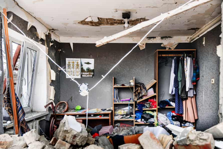 Damage to a room inside house in Hostomel with fallen masonry, rubble and broken furniture.
