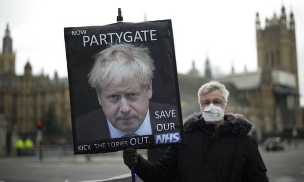 A protester holding a ‘partygate’ placard in Westminster in December