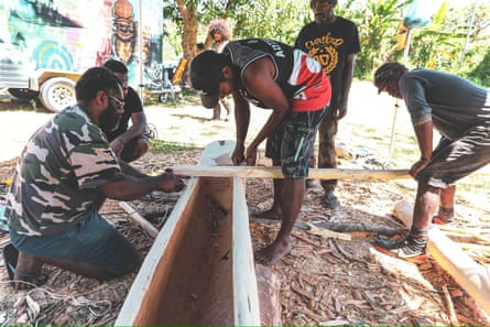 Aile Tikoure (centre) builds a traditional canoe in New Caledonia