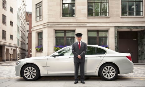 A chauffeur standing by a BMW