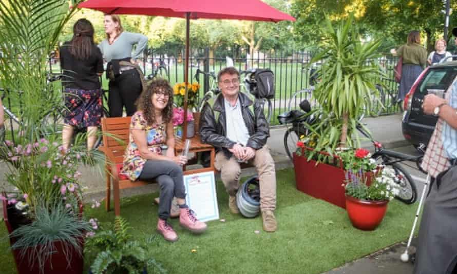Parklet. Man and woman on bench in 'reclaimed' parking space