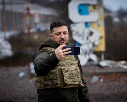 Volodymyr Zelenskyy recording himself on a phone wearing a flak jacket