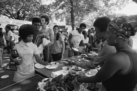 Members of the Black Panther Party stand behind tables and distribute free hot dogs to the public, New Haven, Connecticut, late 1960s or early 1970s.