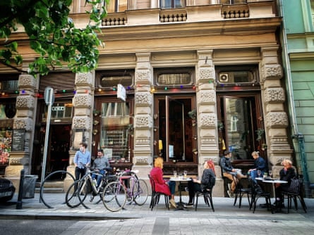 two tables at outdoor bar in front of a grand old building