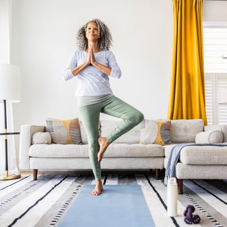 Senior woman doing yoga in living room