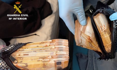 Officers display some of the seized cash