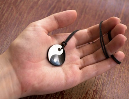 Hand holding a yin-yang necklace