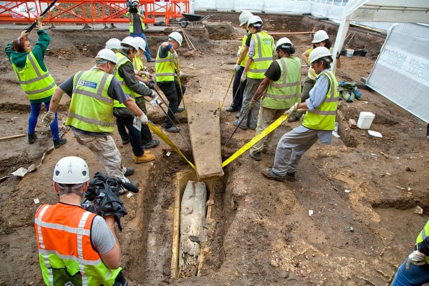 Discovery … helpers lift the lid on the medieval stone coffin found at the site in Leicester.