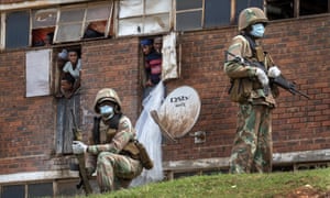 Las fuerzas de defensa nacional sudafricanas patrullan el albergue de hombres en el densamente poblado pueblo de Alexandra al este de Johannesburgo el sábado 28 de marzo de 2020, imponiendo un bloqueo riguroso en un intento por controlar la propagación del coronavirus.