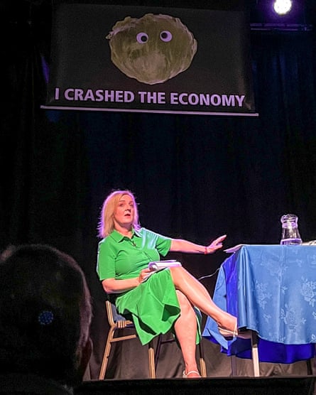 Liz Truss is surprised by a banner that reads “I crashed the economy” at an event in August 2024