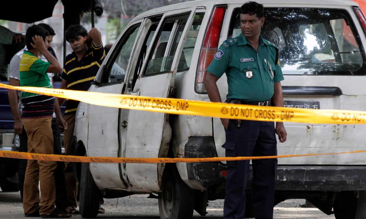 Bangladeshi police at the site where Cesare Tavella was shot in Dhaka