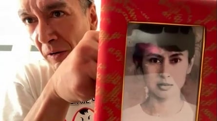 Kim Aris holding an old family photo of his mother, Aung San Suu Kyi.