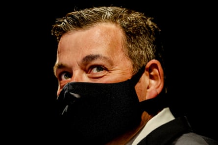 Close-up on Dan Andrews wearing a mask, expression ambiguous