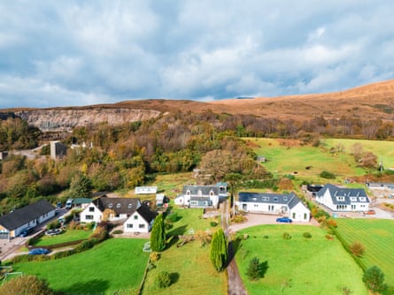 Fort William village homes in an autumnal landscape, with a quarry and mountains behind