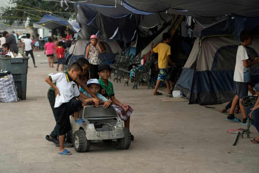 Children pile onto a toy truck amid the tents at the Reynosa encampment.