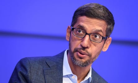 Sundar Pichai in a jacket and open-necked shirt against a blue background