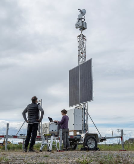 رجل ينظر إلى برج رادار يعمل بألواح شمسية