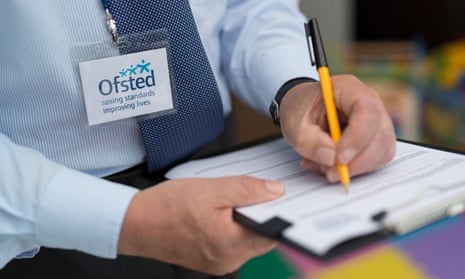 A man from Ofsted compiling a report using a pen and clipboard.