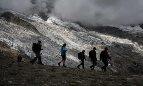 Hikers walking next to the Fee glacier above the Swiss Alps resort of Saas-Fee