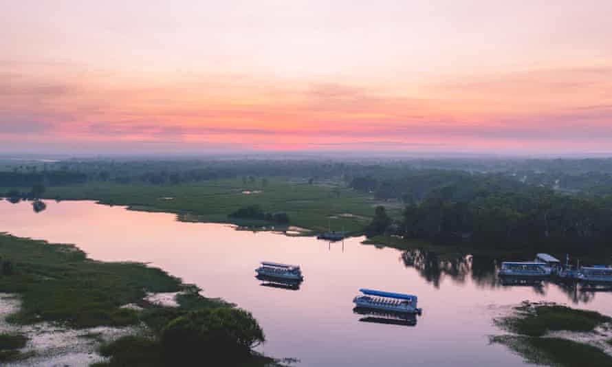 Cruise ships traveling along Yellow Water Billabong at sunrise.
