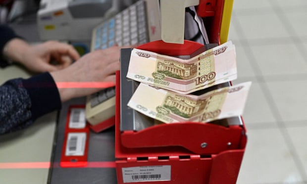 Russian 100-rouble banknotes on a cashier's desk at a supermarket in Tara, Omsk region, Russia.