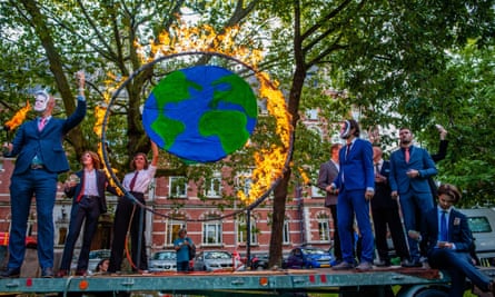 Activists dressed like politicians set fire to a circle representing Earth during a demonstration in Utrecht, Netherlands