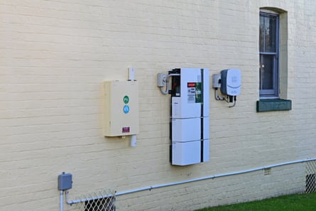 A solar home battery and inverter on a house wall.