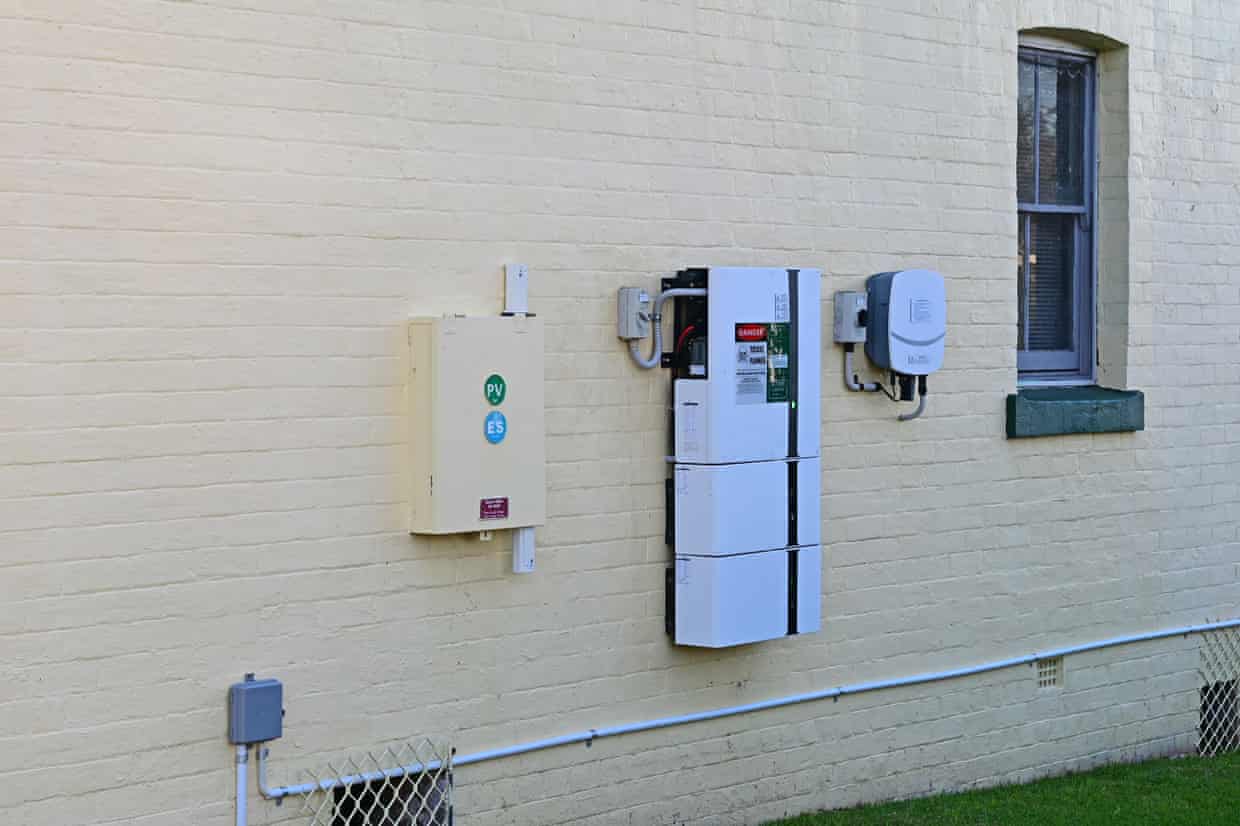 A solar home battery and inverter on a house wall.