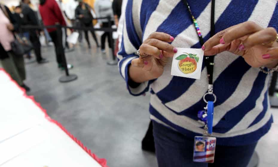 A voter shows off her sticker during early voting in Decatur, Georgia, on 22 October,