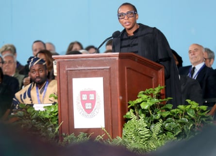 Claudine Gay speaking at a lectern on a stage with others sitting behind her