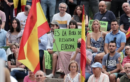 A crowd of people, one holding a sign in Spanish reading ‘Time to rescue Europe’, with others holding the Spanish flag