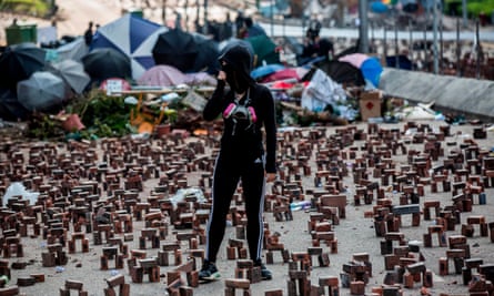 A protester stands amongst bricks placed on a barricaded street outside The Hong Kong Polytechnic University