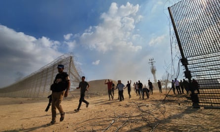 Hamas fighters enter Israel through the border fence in Gaza City on 7 October 2023.