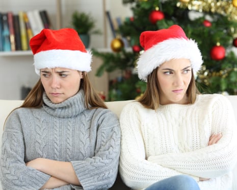 Two angry women at Christmas sitting on a couch in the living room at home