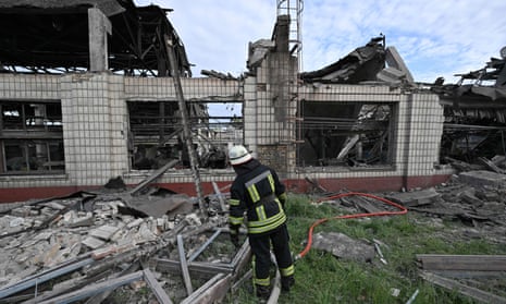A firefighter stands in front of a destroyed production depot of the Darnytsia freight cars repair plant, which was targeted early morning by Russian airstrikes in Kyiv, on June 5, 2022.