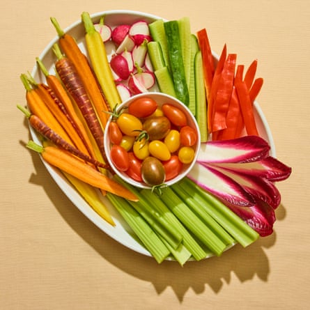 Raw salad vegetables on white plate against beige background