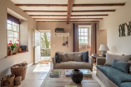 A living room with sofas, a coffee table and beamed ceiling