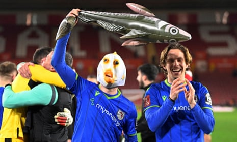 Anthony Driscoll-Glennon wears a fish mask as Grimsby Town celebrate after the final whistle. 