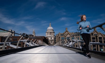 A jogger runs across a deserted Millennium Bridge in London