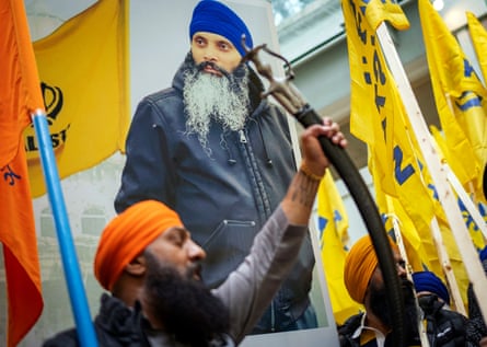 A person holds their arm in the air as others stand by holding flags