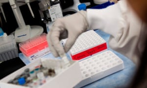In this file photo Dr. Nita Patel, Director of Antibody discovery and Vaccine development, lifts a vial with a potential coronavirus, Covid-19, vaccine at Novavax labs in Gaithersburg, Maryland on March 20, 2020, one of several labs developing a vaccine for the coronavirus.