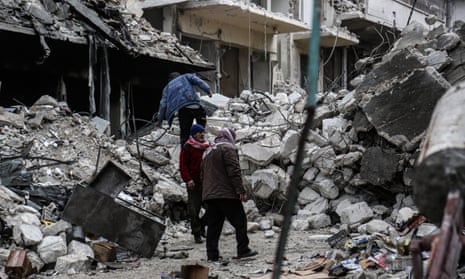Locals inspect damaged buildings after Russian warplanes hit residential areas in Idlib