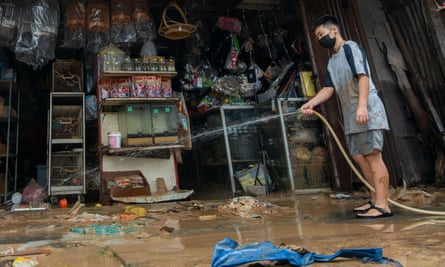 A man hoses down his flooded shop in Selangor.