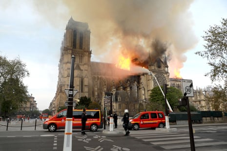 Firefighters douse the cathedral with water from hoses.