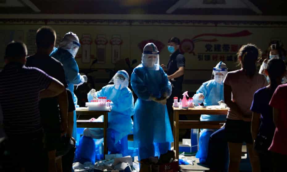 Medical workers attend to people lining up for nucleic acid coronavirus testing at a residential compound in Ruili, Dehong prefecture, Yunnan province, China 16 September 2020.