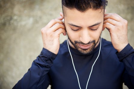 Man holding wired headphones in his ears