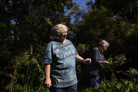Deux femmes debout dans un jardin verdoyant à la recherche de plantes