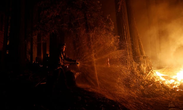 Cal Fire firefighter Anthony Quiroz defends a home in Boulder Creek, California, during the CZU Lightning Complex Fire.